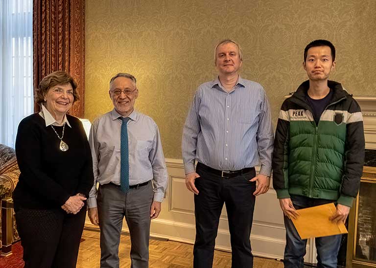 The inaugural Lloyd Orr Dissertation Fellowship Recipient, Chao Wang, poses with Jackie Hall, Michael Kaganovich, and Volodymyr Lugovskyy