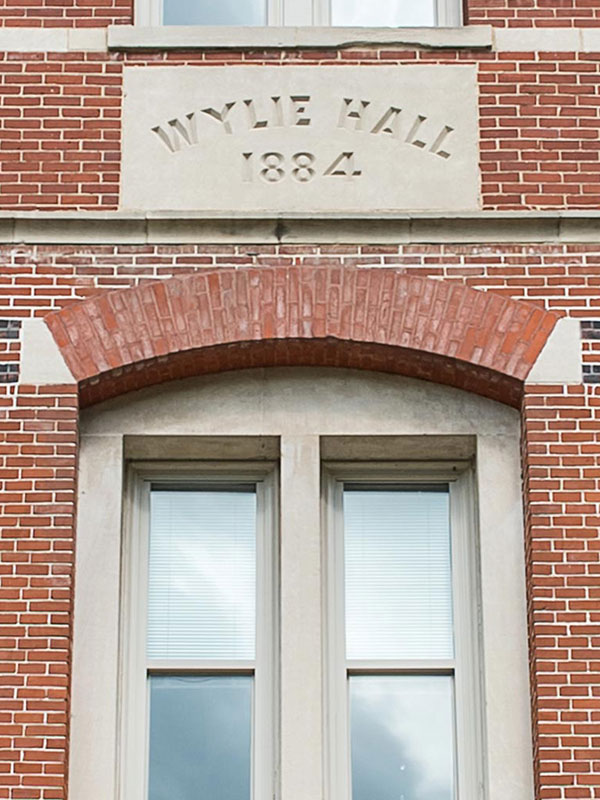 An exterior short of Wylie Hall, which is made of brick and has a limestone seal.