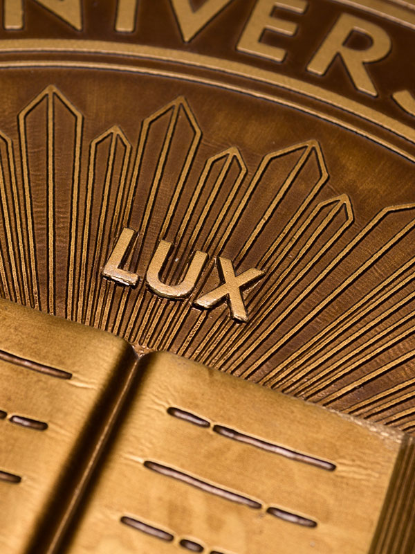 A close-up of the university's "Lux et Veritas" seal, in bronze.