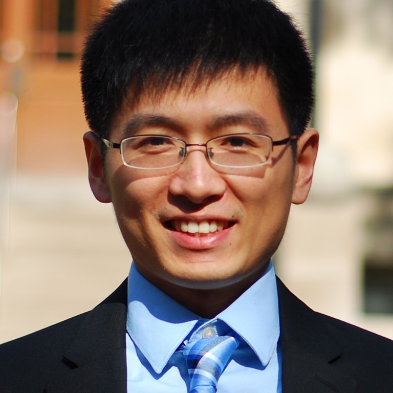 A headshot of Bo Hu, who wears a black suit and blue tie.